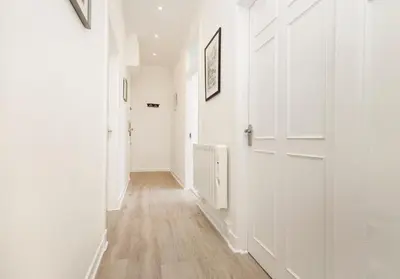 a hallway with white walls and a white door at Argyl - Charming 2 Bedroom Apartment on Thistle Street in Edinburgh