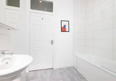 a white bathroom with a shower and a sink at Argyl - Charming 2 Bedroom Apartment on Thistle Street in Edinburgh