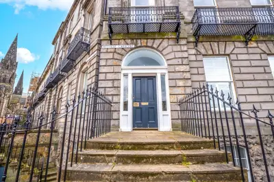 a blue door on a stone building with stairs at Flat with Majestic views in West End Wonderland in Edinburgh