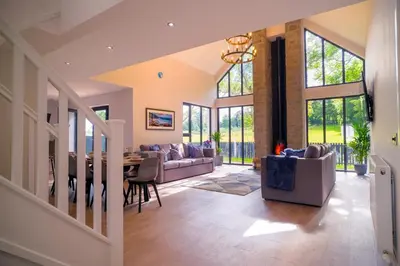 a large living room with a table and chairs at Lowwood Lodges in Houston