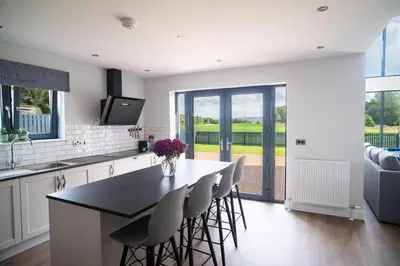 a kitchen with a table and chairs and a television at Lowwood Lodges in Houston