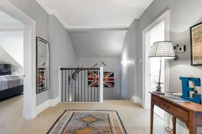 a living room with a staircase with a rug at Super Central - Georgian Double Upper Flat with Castle Views in New Town in Edinburgh