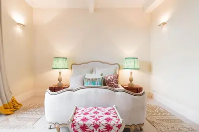 a room with a bed with pillows and two lamps at Super Central - Georgian Double Upper Flat with Castle Views in New Town in Edinburgh
