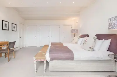 a bedroom with a large bed and a table at Super Central - Georgian Double Upper Flat with Castle Views in New Town in Edinburgh