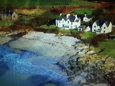a painting of a house next to a beach at Unique house in an idyllic situation on a beach in Port Ellen