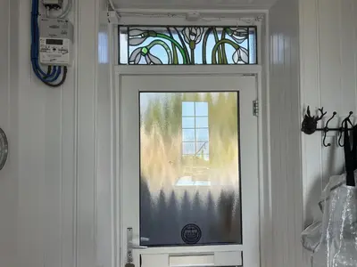 a door with a glass window and a window at Unique house in an idyllic situation on a beach in Port Ellen