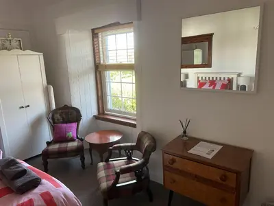 a bedroom with a bed and a table and chairs at Unique house in an idyllic situation on a beach in Port Ellen