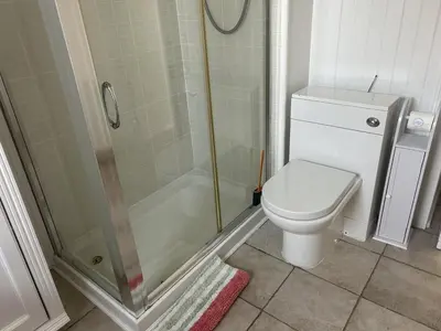 a bathroom with a toilet and a glass shower at Unique house in an idyllic situation on a beach in Port Ellen
