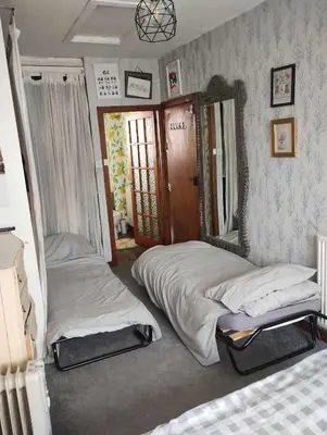 a bedroom with two beds and a mirror at Silverknowes Silver room sleeps 4 with private shower in Edinburgh