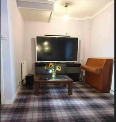 a living room with a tv and a coffee table at Silverknowes Silver room sleeps 4 with private shower in Edinburgh