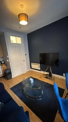 a living room with a tv and a glass table at Homely in Hampden in Glasgow