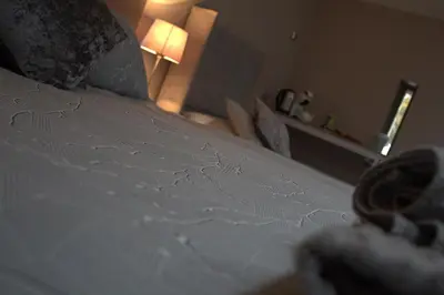 a close up of a white bed in a bedroom at The Old Mill Bed & Breakfast in Biggar