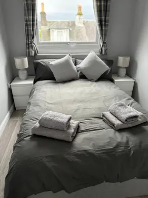 a large bed with two towels on it in a bedroom at Largs Seaside Loft 2 R in Largs