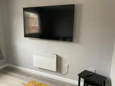 a flat screen tv hanging on a white wall at Largs Seaside Loft 2 R in Largs