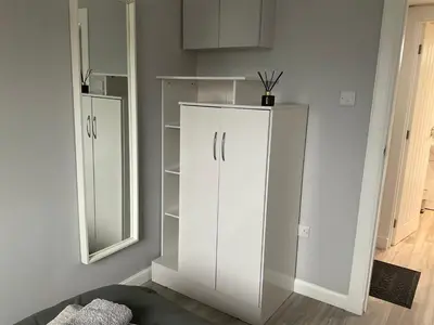 a white cabinet in a room with a mirror at Largs Seaside Loft 2 R in Largs