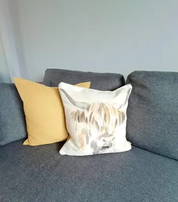 a dog on a pillow on a couch at Largs Seaside Loft 2 R in Largs