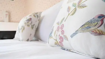 a bed with a pillow with a bird on it at Beautiful House With Gardens Close To River Tay in Remony