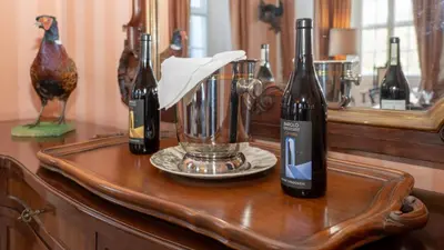 three bottles of wine on a table with a chicken at Beautiful House With Gardens Close To River Tay in Remony