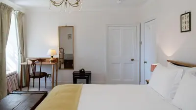 a bedroom with a bed and a desk and a window at Beautiful House With Gardens Close To River Tay in Remony