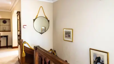 a hallway with a mirror on a wall at Beautiful House With Gardens Close To River Tay in Remony
