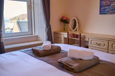 a bedroom with a bed with two towels on it at Oban Bay Views - Fireplace, Games & Books in Oban