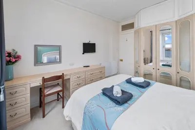 a bedroom with a bed and a desk and a television at Oban Bay Views - Fireplace, Games & Books in Oban