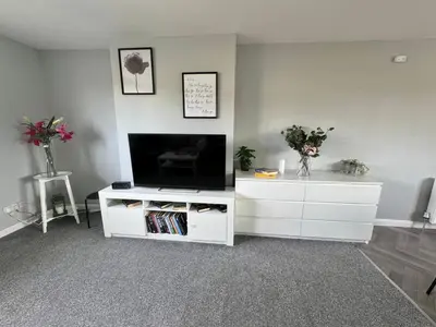 a living room with a tv and a white entertainment center at ClydeBank Brand new 3BDR Home, Glasgow in Clydebank
