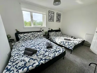 a bedroom with two beds and a window at ClydeBank Brand new 3BDR Home, Glasgow in Clydebank