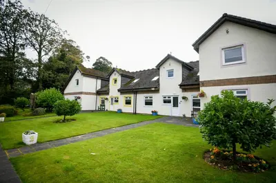a large white house with a green yard at Cunninghame 4 in Beith