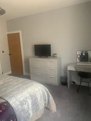 a bedroom with a bed and a desk and a television at House Aurora in Edinburgh
