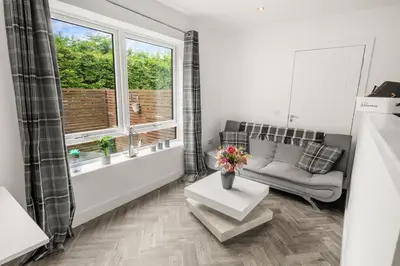 a living room with a couch and a window at Beautiful 1 BR apt with private patio and free parking in Dunollie