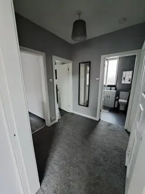 an empty living room with two doors and a mirror at Glasgow Apartment close to the airport in Renfrew