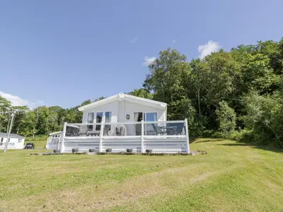 a white house on a field with trees at Bethany's Retreat in Wemyss Bay