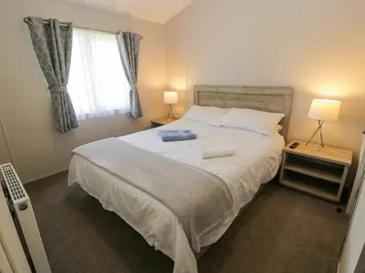 a bedroom with a large bed and a window at Olivia's Haven in Wemyss Bay