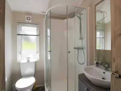 a bathroom with a shower and a toilet and a sink at Olivia's Haven in Wemyss Bay