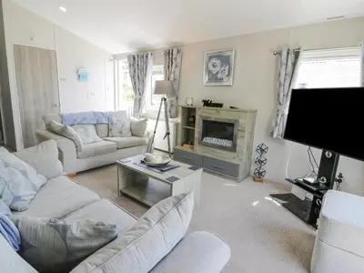 a living room with couches and a flat screen tv at Olivia's Haven in Wemyss Bay