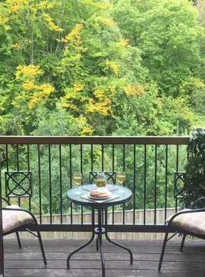 a table on a balcony with two glasses of wine at The Pentland Apartment in Penicuik