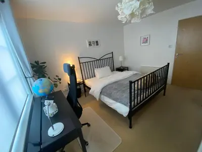 a bedroom with a bed and a table with a desk sidx sidx sidx at The Pentland Apartment in Penicuik