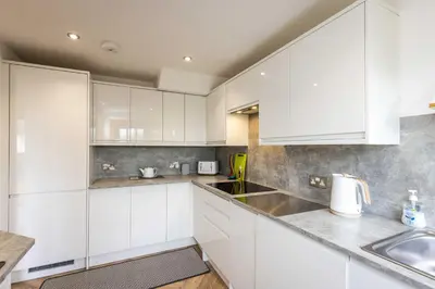 a kitchen with white cabinets and a sink at 20 mins to Edinburgh 3 bedroom detached family house Wi-Fi Parking in Fife