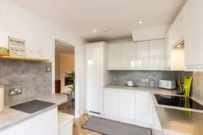 a kitchen with white cabinets and a sink at 20 mins to Edinburgh 3 bedroom detached family house Wi-Fi Parking in Fife