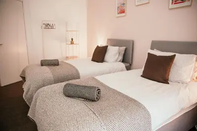 two beds in a room with a bag on the bed at 4 Beds - City Gateway Getaway with Free Parking in Glasgow