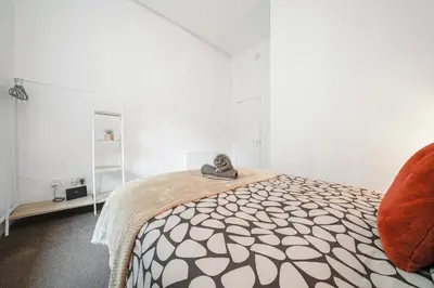 a bedroom with a bed with a pair of shoes on it at 4 Beds - City Gateway Getaway with Free Parking in Glasgow