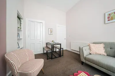 a living room with a couch and a chair and a table at 4 Beds - City Gateway Getaway with Free Parking in Glasgow