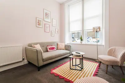 a living room with a couch and a table at 4 Beds - City Gateway Getaway with Free Parking in Glasgow