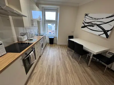 a kitchen with a counter and a table and a table at Heart of Oban in Oban