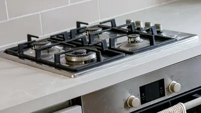 a stove top oven with four burners on it at Modern And Cozy Apex Apartment in Helensburgh