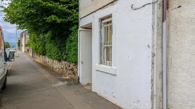 a white building with a window on the side of a street at Modern And Cozy Apex Apartment in Helensburgh