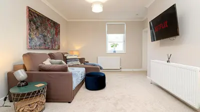 a living room with a couch and a crib at Modern And Cozy Apex Apartment in Helensburgh