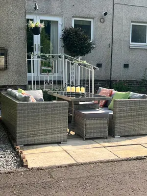 two wicker couches and a table in front of a house at Loch Lomond Riverside Apartments A in Balloch