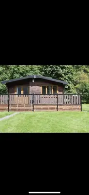 a large house with a wooden fence in a yard at Lomond View Lodge in Glasgow
